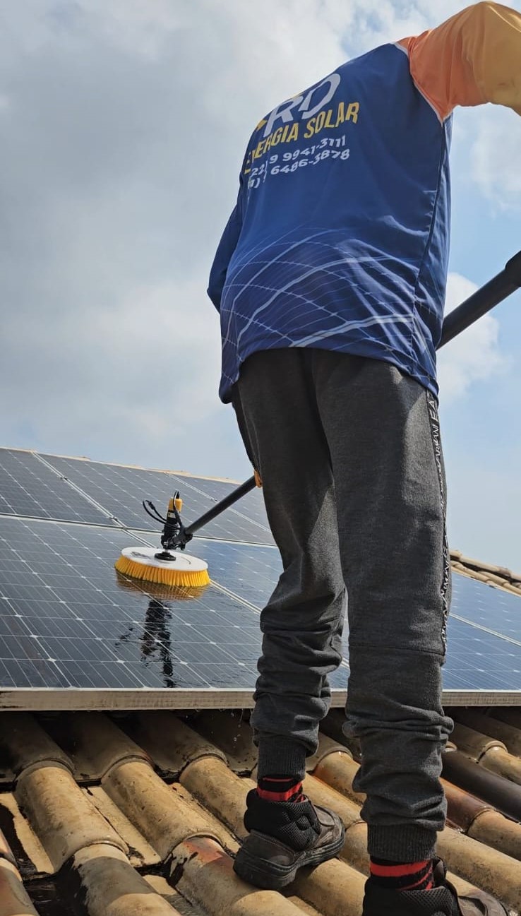 Técnico da RD Energia Solar limpando os painéis de um sistema fotovoltaico