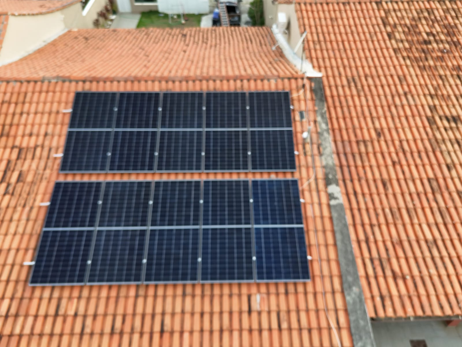 Detalhe de módulos solares instalados em telhado residencial